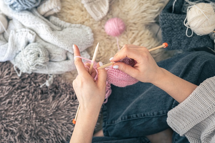 woman knitting a pink scarf