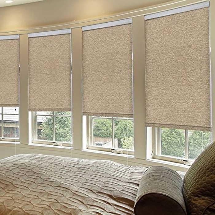 a bedroom with big windows with blinds of fabric
