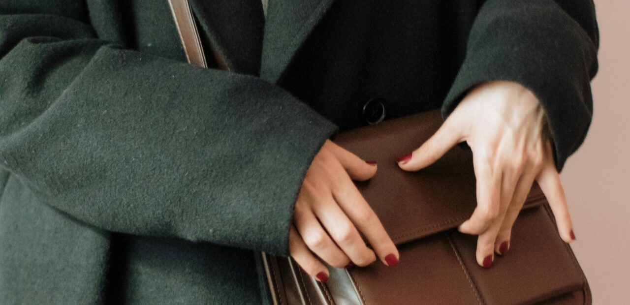 woman holding brown leather bag