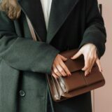 woman holding brown leather bag