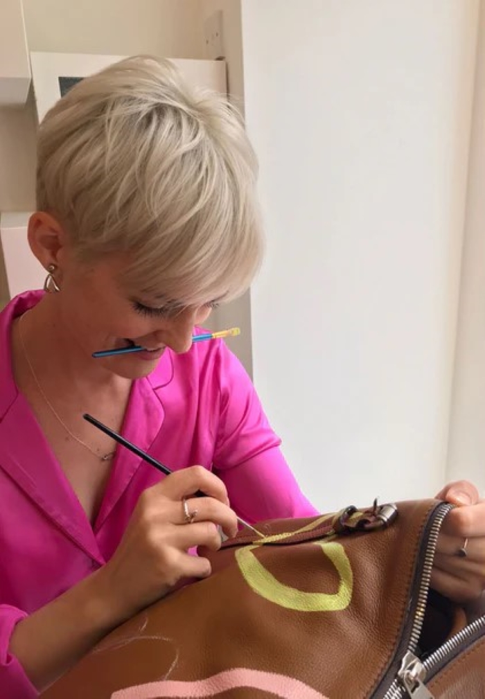 woman using leather paint for a leather bag