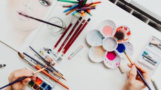 person painting with watercolour paints and pencils